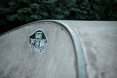 man getting tattooed wearing vans checkerboard shoes