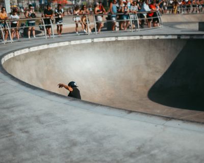 man with hair holding vans checkerboard shoes in a prayer position