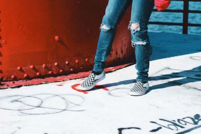 man skateboarding at a skate park wearing vans checkerboard slip ons