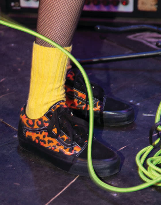 A cheetah print Premium Old Skool Vans shoe tangled in musical cords. 